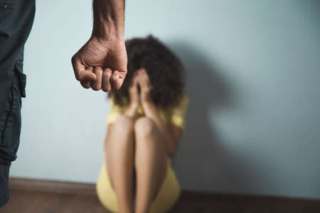 angry man beat woman on dark background