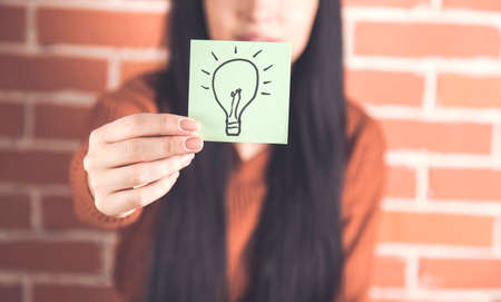 woman hand holsing bulb on the paper