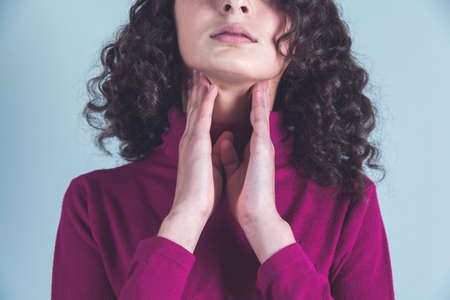 man hand in ache throat on gray backgroundの写真素材