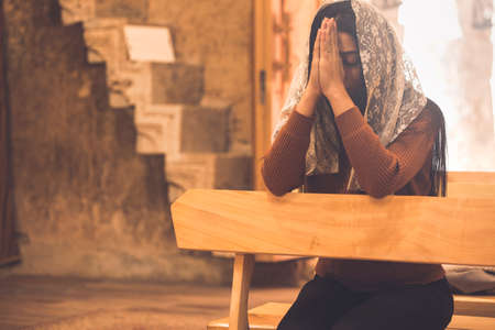 young sad woman praying in church background