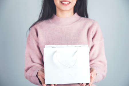 woman hand shopping bags on gray wall backgroundの写真素材