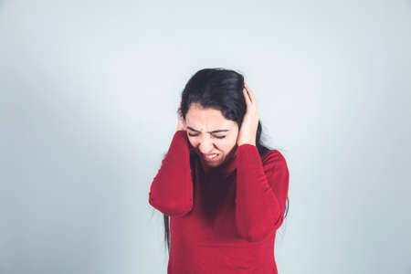 sad woman hand close ear on gray backgroundの写真素材