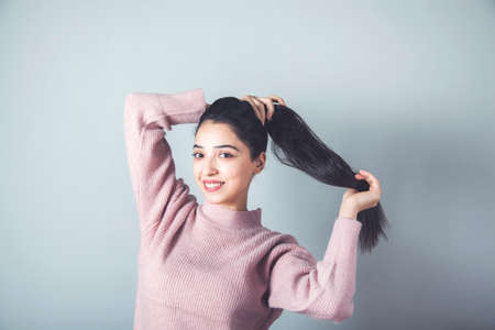woman hand  tail hair on gray backgroundの写真素材