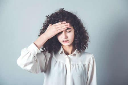 woman hand in ache head on gray backgroundの写真素材