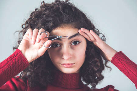 woman hand tweezers on the gray backgroundの写真素材
