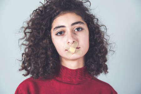 sad women lip plaster on gray background