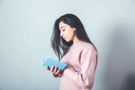 woman hand notepad on gray wall backgroundの写真素材