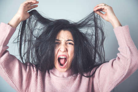 angry woman hand hair on grey backgroundの写真素材