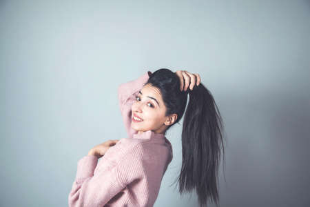 happy woman tie the hair on grey backgroundの写真素材