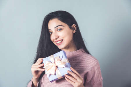 happy woman hand gift box on grey backgroundの写真素材