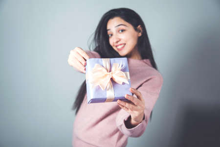 happy woman hand gift box on grey backgroundの写真素材