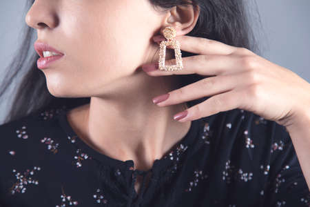 woman hand elegant earring on grey backgroundの写真素材