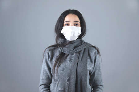 ill woman face mask on grey backgroundの写真素材