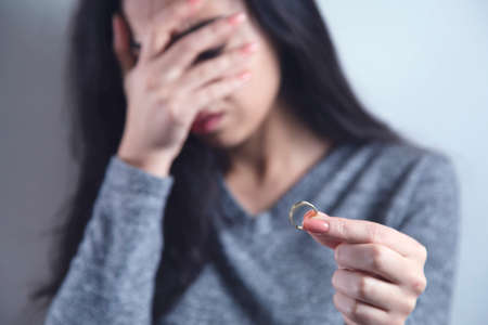 sad woman hand ring on grey background