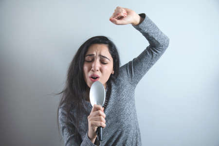 woman hand comb sings on grey background