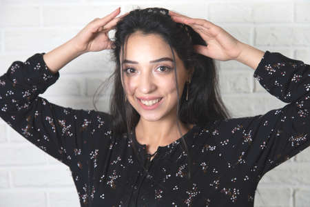 happy woman hand in hair on brick wall backgroundの写真素材