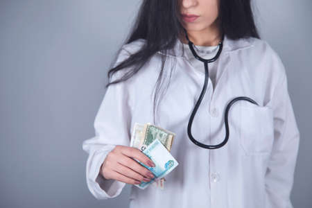 doctor hand money on grey wall backgroundの写真素材