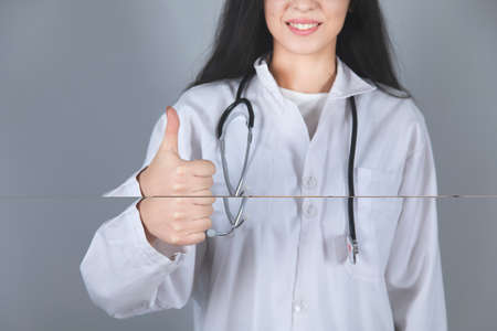 happy doctor hand okay sign on grey backgroundの写真素材