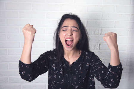 happy woman hand yes sign on brick wall backgroundの写真素材