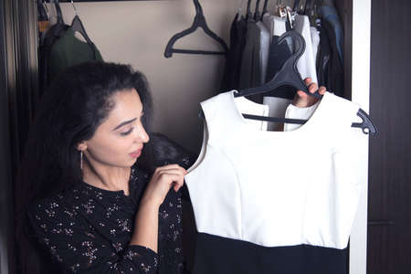 woman choose clothes from the closet in roomの写真素材