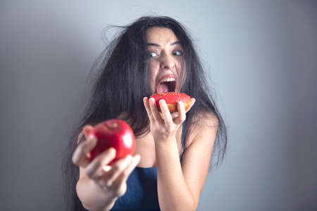 sad woman hand donut and appleの写真素材