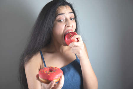 happy woman hand holding Donut and appleの写真素材