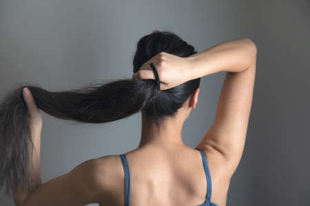 woman tail tie the hair on grey backgroundの写真素材