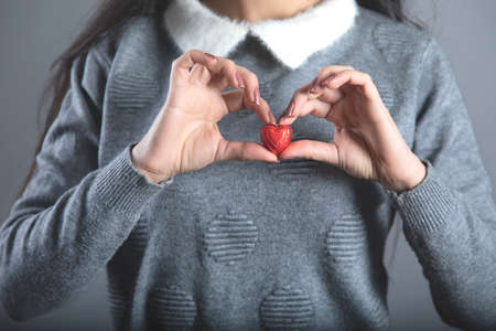 young woman hand holding candies red heartの写真素材
