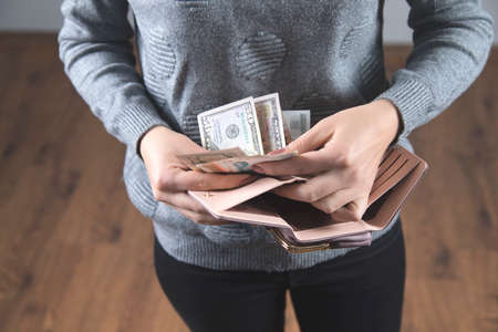 woman hand money with wallet on grey background