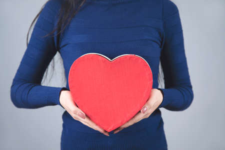 happy woman hand heart box on grey backgroundの写真素材