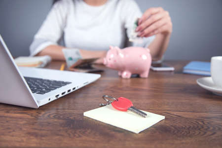 woman hand money with piggy bank on working deskの写真素材