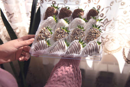 woman hand chocolate strawberries in a boxの写真素材