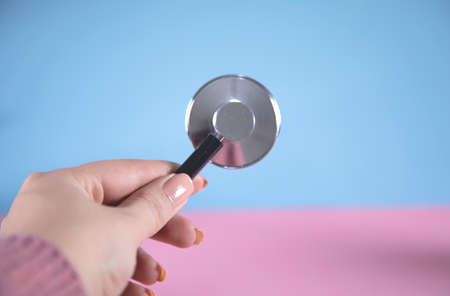 woman hand stethoscope on grey wall backgroundの写真素材