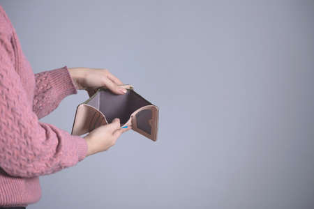 woman hand empty wallet on grey backgroundの写真素材