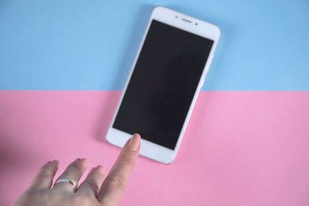 young woman hand holding white smart phoneの写真素材