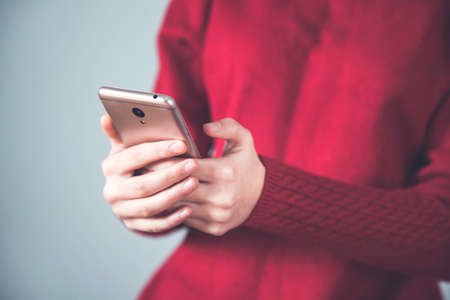 woman hand holding smart phone on grey background