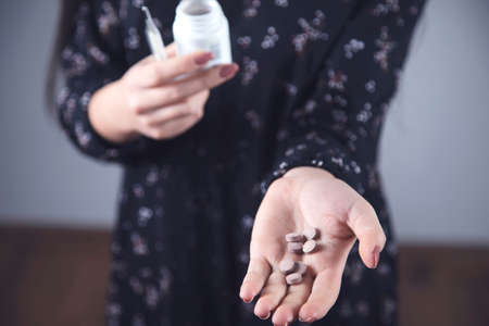 young ill woman hand drug and thermometerの写真素材