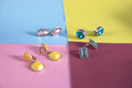 different and colorful earrings on the color backgroundの写真素材