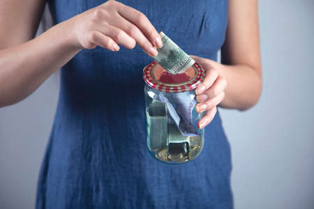happy woman hand money in jaron grey background
