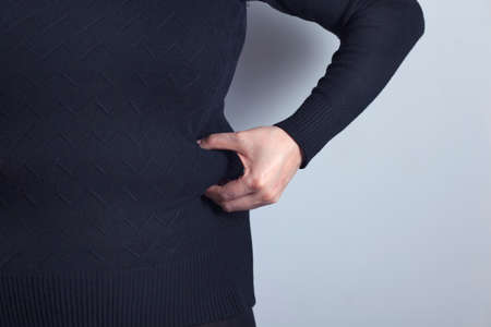 Fat overweight woman pinching her fat tummy 