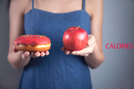 happy woman hand holding Donut and appleの写真素材