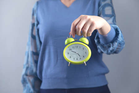 woman hand clock on grey wall backgroundの写真素材
