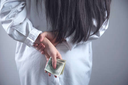 woman doctor hand money in back on grey backgroundの写真素材