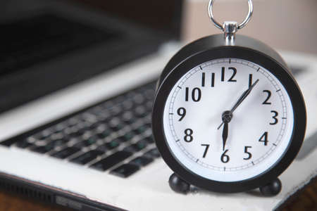 clock with computer on the table background