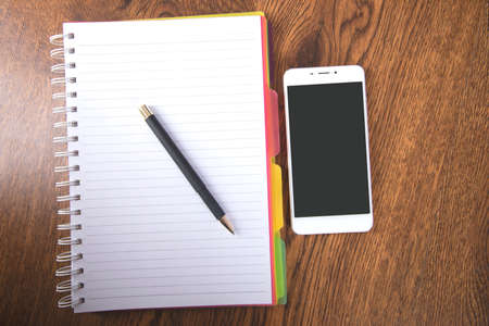pen with notepad and smart phone on the tableの写真素材