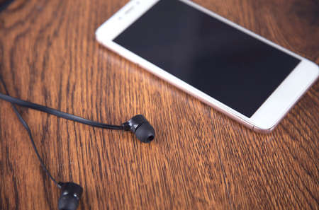 Earphone and smart phone on the table backgroundの写真素材