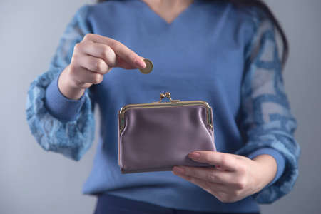 woman hand holding wallet with coins
