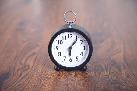 clock on the wooden table background
