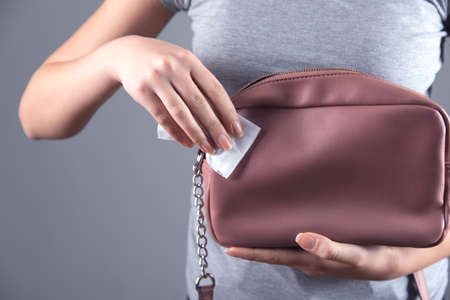 woman cleaning pink bag on grey backgroundの写真素材