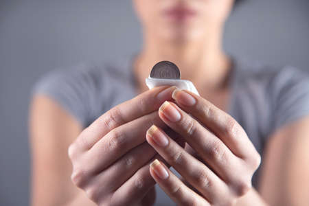 woman clean coin on grey background